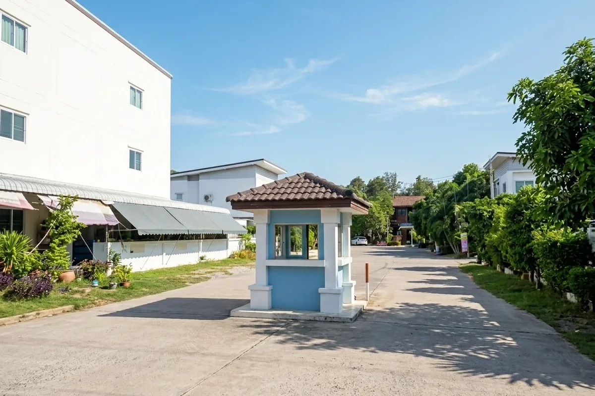 Saen Charoen Orchid Park street view with a large white house, red gate, and a pickup truck parked on the road.