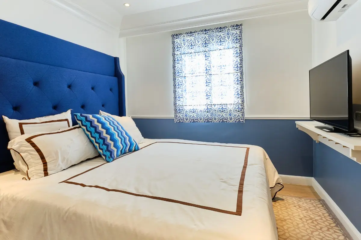 1 Bedroom Condo for Sale at Seven Seas Cote d'Azur, bedroom with blue headboard, white bedding, and TV.