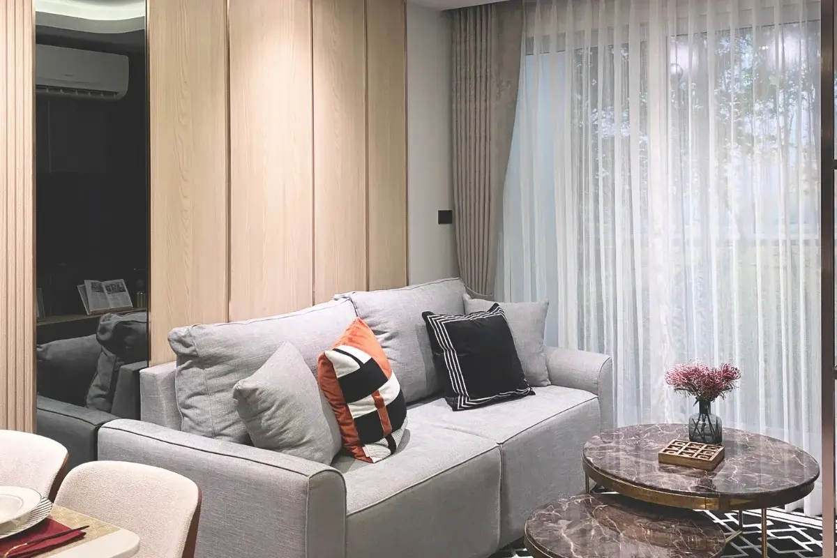 1 Bedroom Condo for Sale at Pristine Park 3, modern living room with gray sofa, marble coffee table, and sheer curtains.