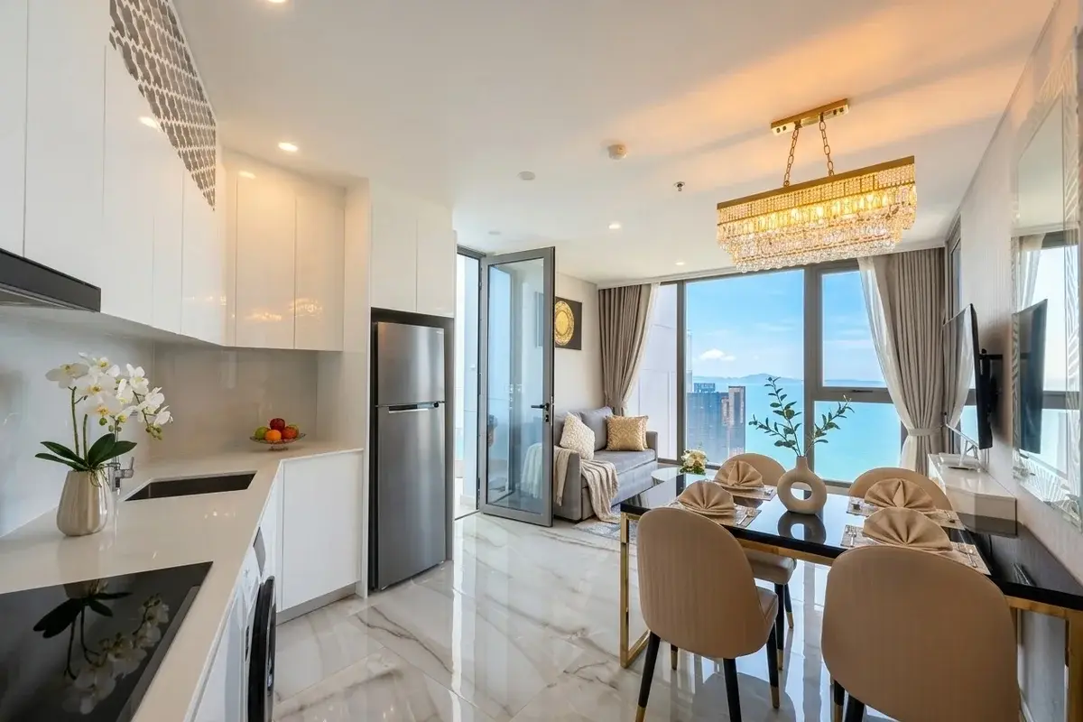1 Bedroom Condo for Sale at Copacabana Beach Jomtien open-plan living area with kitchen, dining, and sea view balcony.