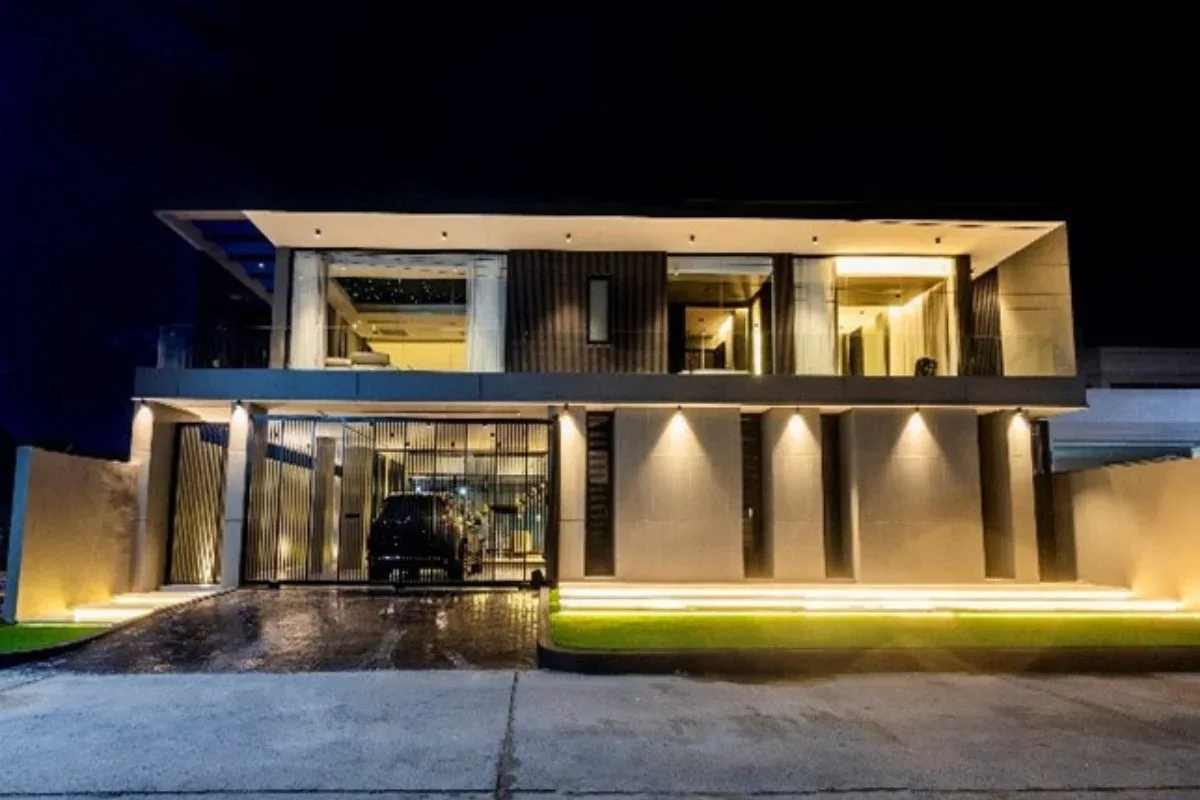5 Bedroom House for Rent at Casa Jomtien: Modern exterior at night with illuminated facade, garage, and driveway.