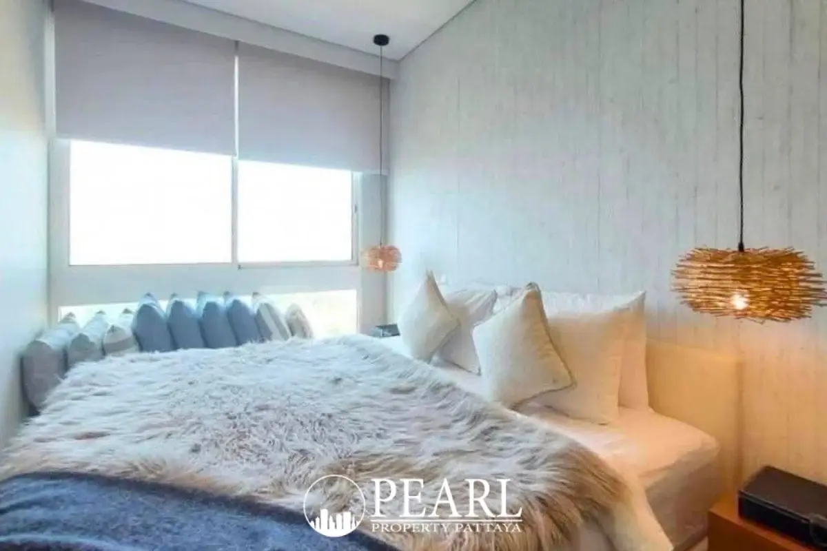 2 Bedroom Condo for Sale at Veranda Residence Pattaya bedroom with furry throw and large window.