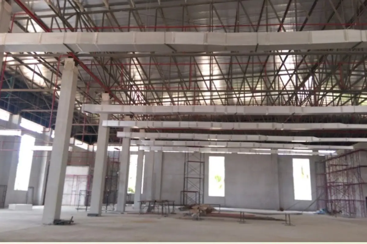 Land for Sale in Nong Pla Lai, interior of a large industrial building under construction with exposed beams and ductwork.