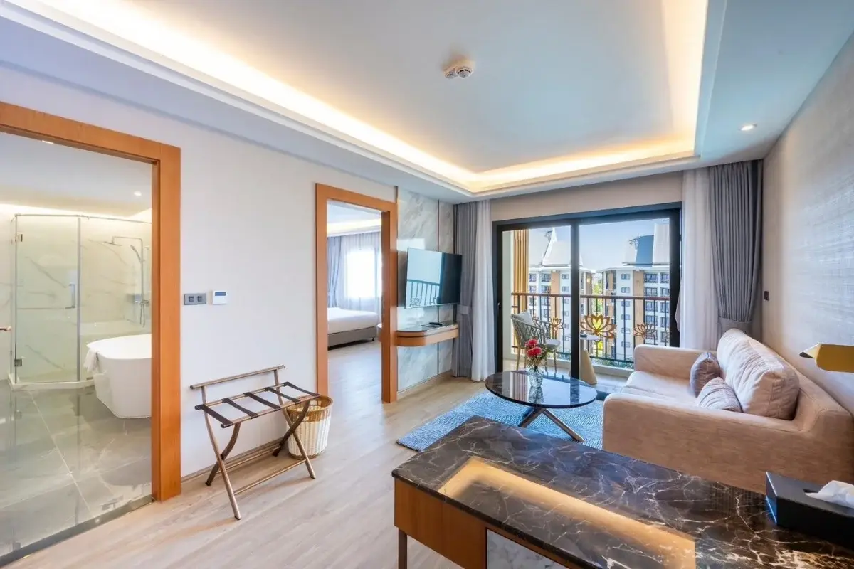 1 Bedroom Condo for Sale at Wyndham Jomtien Pattaya: Living room with sofa, coffee table, TV, and balcony view.