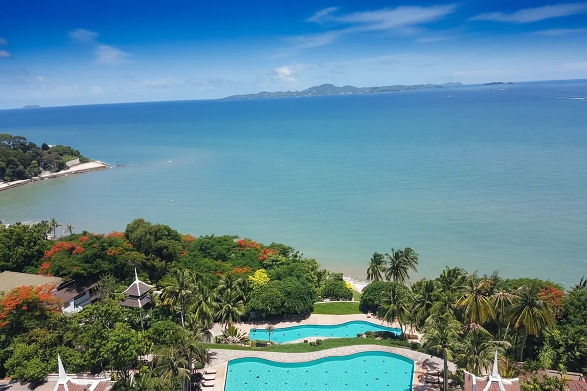 Royal Cliff Garden aerial view of two large outdoor pools, green landscape, and blue ocean with islands.