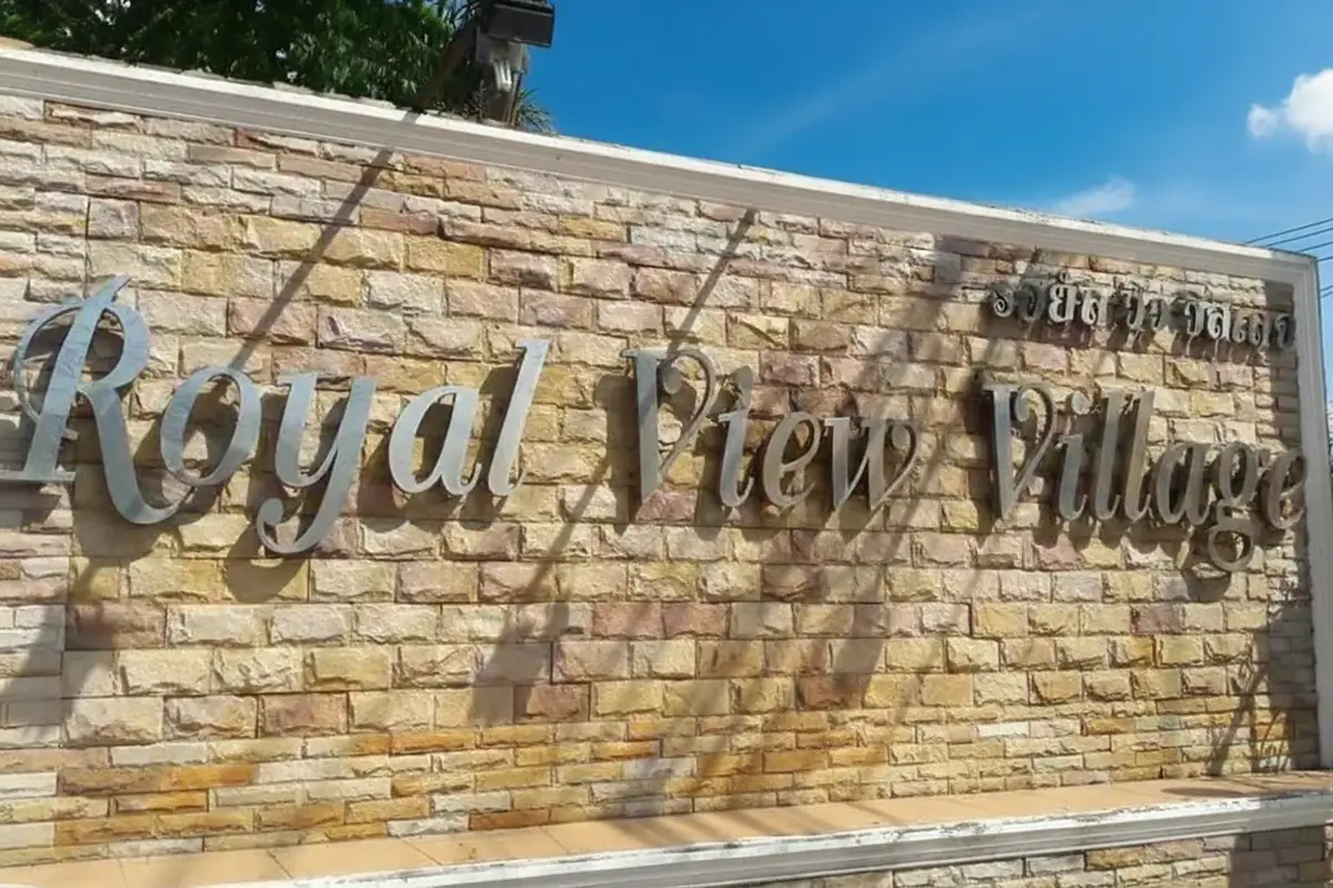 Royal View Village entrance sign made of stone with metal lettering.