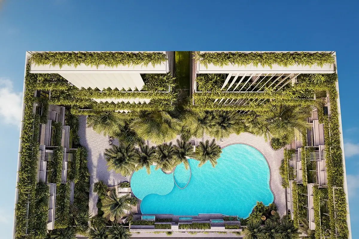 Siam Oriental Oasis large, irregularly shaped swimming pool with sun loungers, surrounded by tropical plants and a building facade.