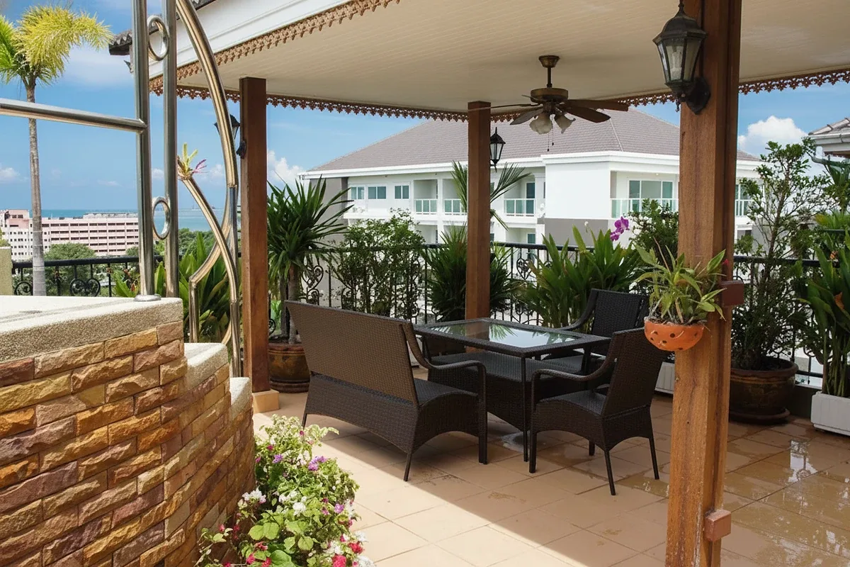 Siam Oriental Twins outdoor patio with a dining table, chairs, ceiling fan, and potted plants.