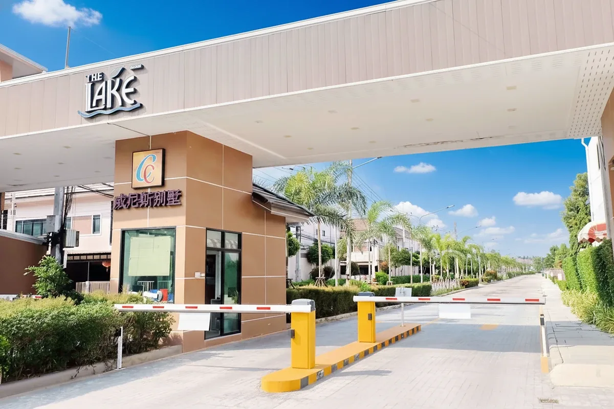 The Lake Huay Yai main entrance gate with security booth, boom barriers, and community street.