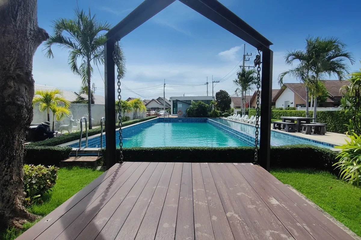 The Maple Pattaya entrance sign with a large red maple leaf logo and manicured shrubs.