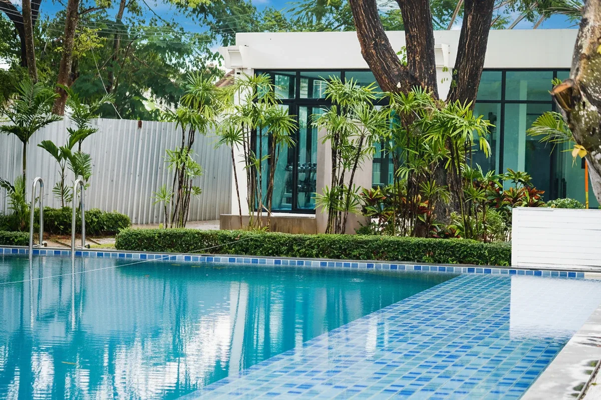 The Maple Pattaya large outdoor swimming pool with blue tiles and a pink flamingo float.