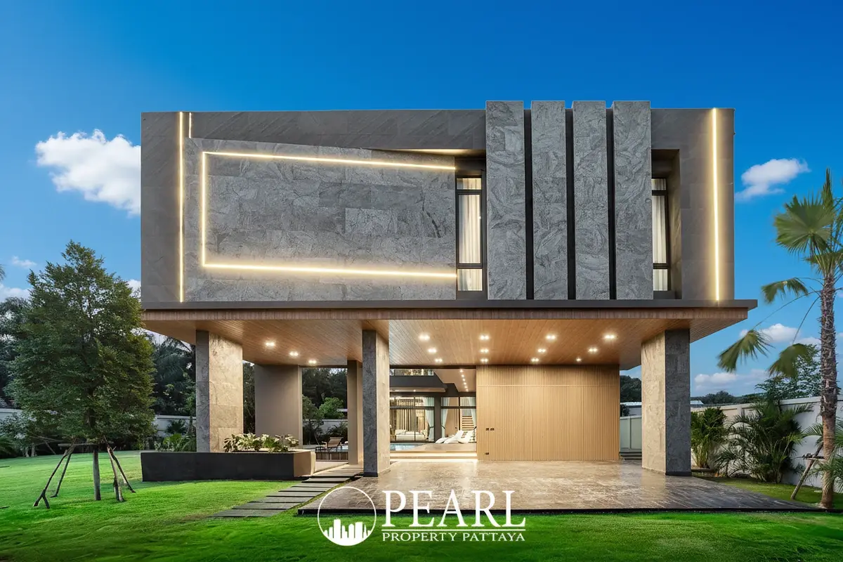 The Sylva Pattaya front entrance with illuminated facade, covered parking, and palm trees.