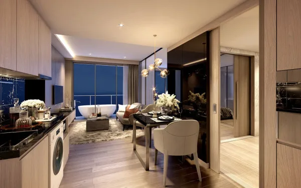 The Panora Pattaya living room and dining area with a sofa, dining table, and ocean view balcony.