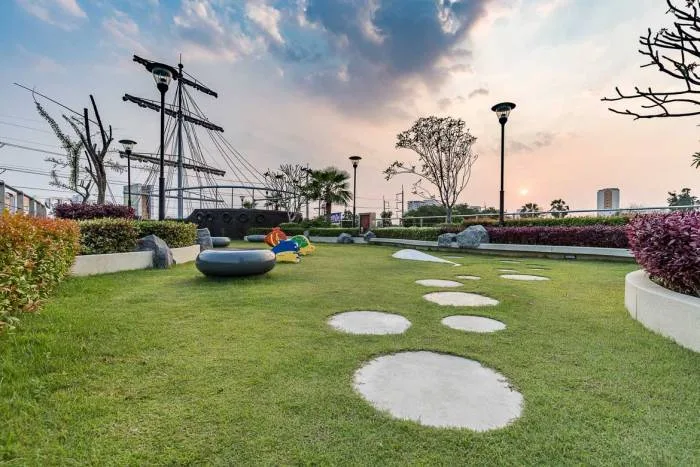 Supalai Mare Pattaya entrance with a circular building featuring 7-Eleven and a tall modern condo tower.