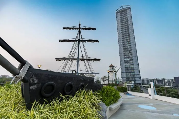 Supalai Mare Pattaya rooftop swimming pool with a white waterslide and a tall residential building.