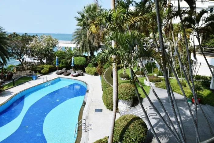 Sugar Beach balcony view of the swimming pool, tropical garden, and distant ocean.