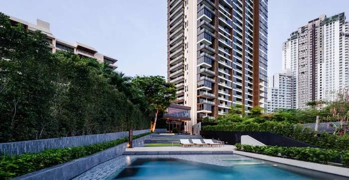 Baan Plai Haad exterior with ground-floor lounge chairs, wooden deck, green lawn, and small pool.