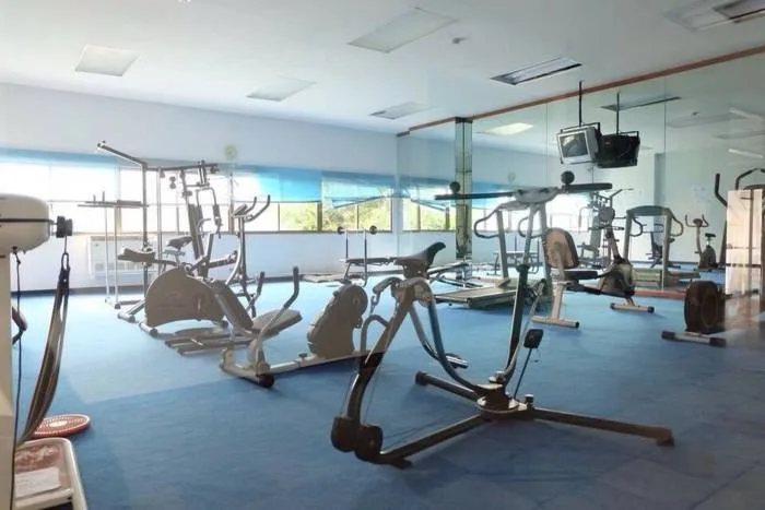 Kieng Talay large outdoor swimming pool with blue tiles, surrounded by tall condo buildings and green trees.