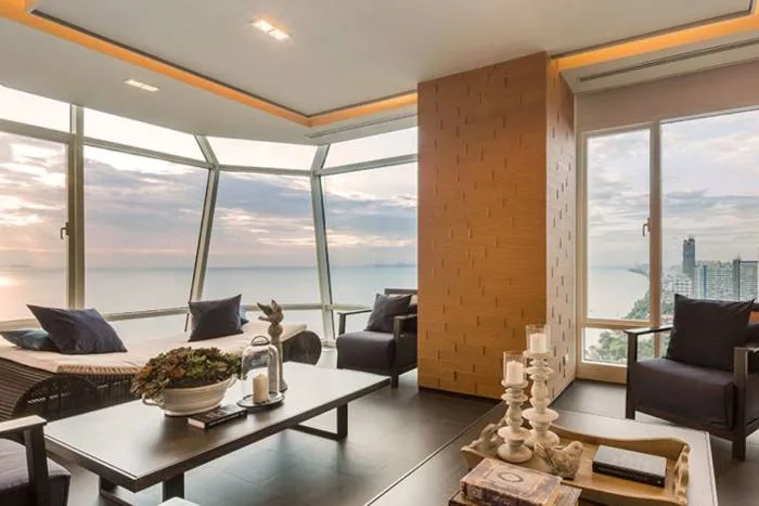 Reflection Jomtien Beach: Outdoor balcony with dining table set for two, overlooking the ocean at sunset.