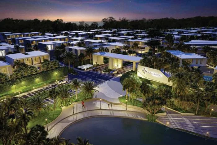 Glory Village Pattaya open-plan living area with high ceilings, white floors, and a kitchen island.