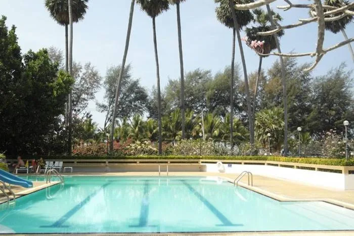 Grand Condotel outdoor swimming pool with blue slide, lounge chairs, and condo building in background.