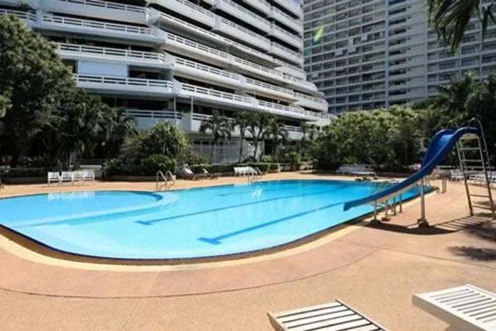 Grand Condotel outdoor swimming pool surrounded by tall palm trees and tropical greenery.