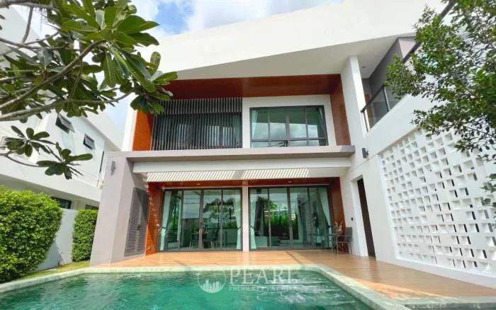 The S concepts modern house exterior with a swimming pool, wooden deck, and large glass doors on the ground floor.
