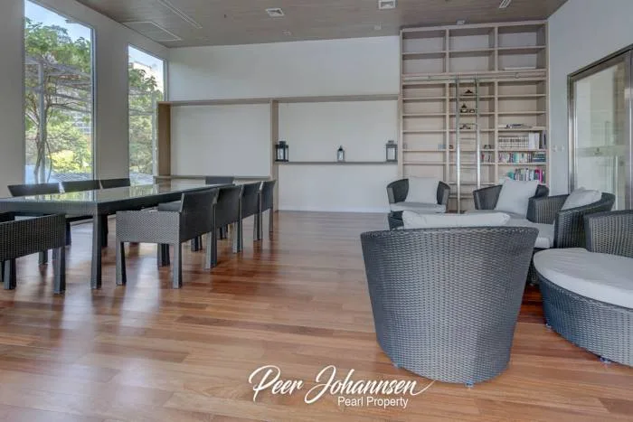 The Cove Pattaya large outdoor swimming pool with a water feature in the foreground and ocean view.