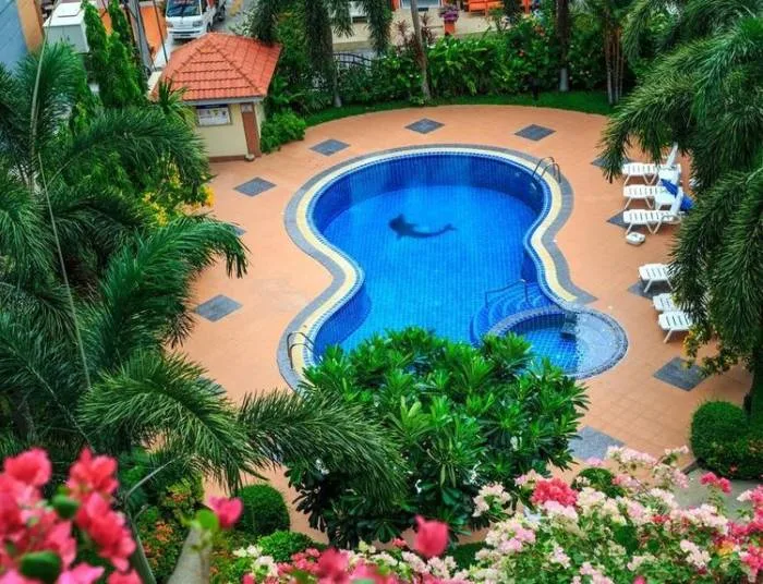 Nordic Residence building exterior covered in vibrant pink and white flowers, with a prominent entrance sign and palm trees.