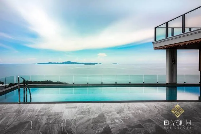 Elysium Residences infinity pool overlooking the ocean and distant islands under a blue sky.