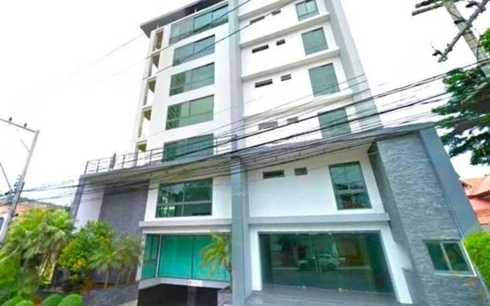 Sunrise Hill Residence exterior view of a modern multi-story building with large windows and stone cladding.