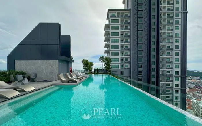 Arcadia Millennium Tower rooftop infinity pool with lounge chairs, overlooking the city and adjacent buildings.
