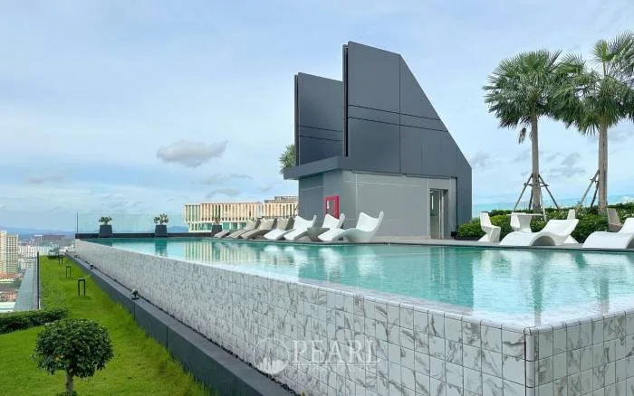 Arcadia Millennium Tower rooftop infinity pool with lounge chairs and palm trees, offering panoramic city views.