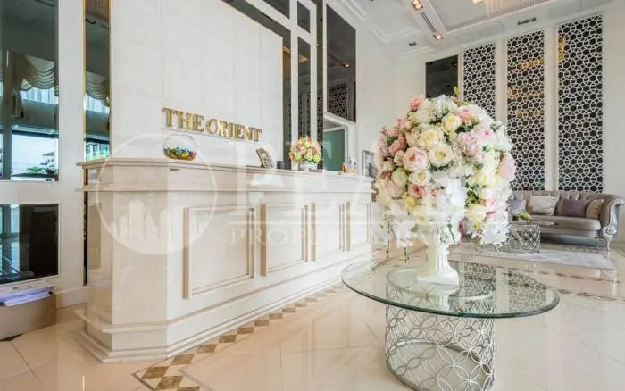 The Orient Resort & Spa outdoor swimming pool area with a water slide and surrounding lush greenery.