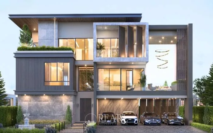 Harmony Hills Villas Pattaya: Modern villa exterior at dusk with large windows, illuminated interior, and carport with cars.