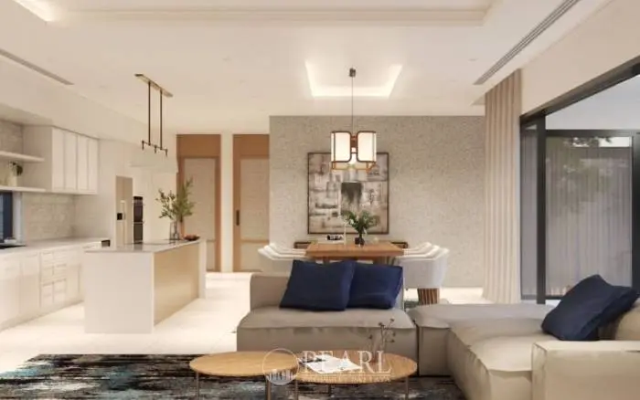 Prime Habitat open-plan living room and dining area with a white sofa, wooden dining table, and kitchen island.