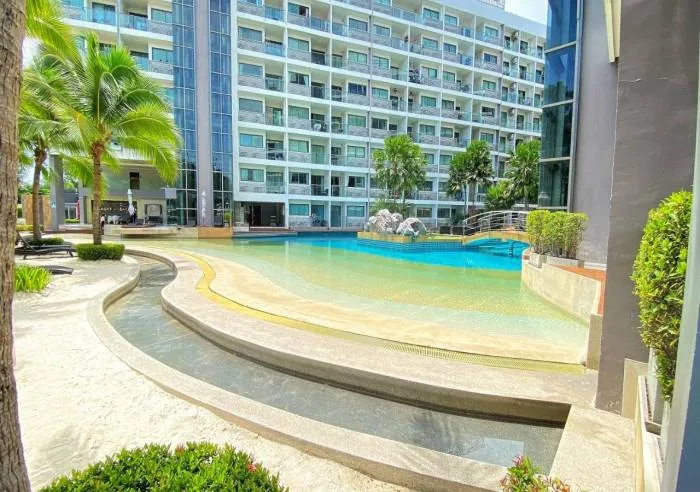 Laguna Beach Resort 1 large lagoon-style swimming pool with a bridge, artificial beach, and multi-story building.