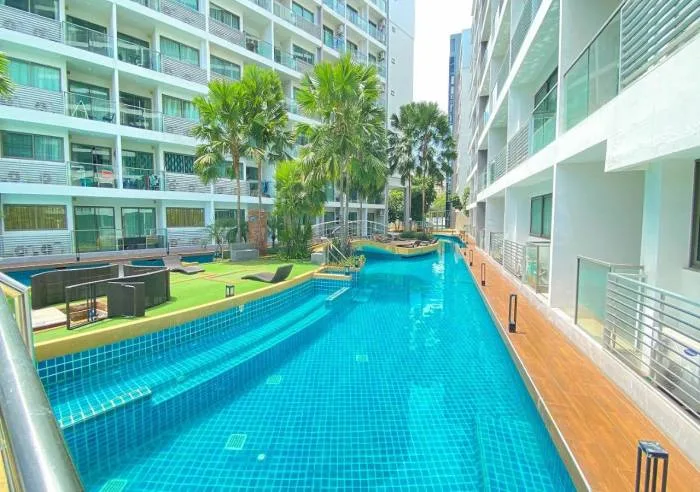 Laguna Beach Resort 1 long, narrow swimming pool between two condo buildings, with artificial grass and loungers.