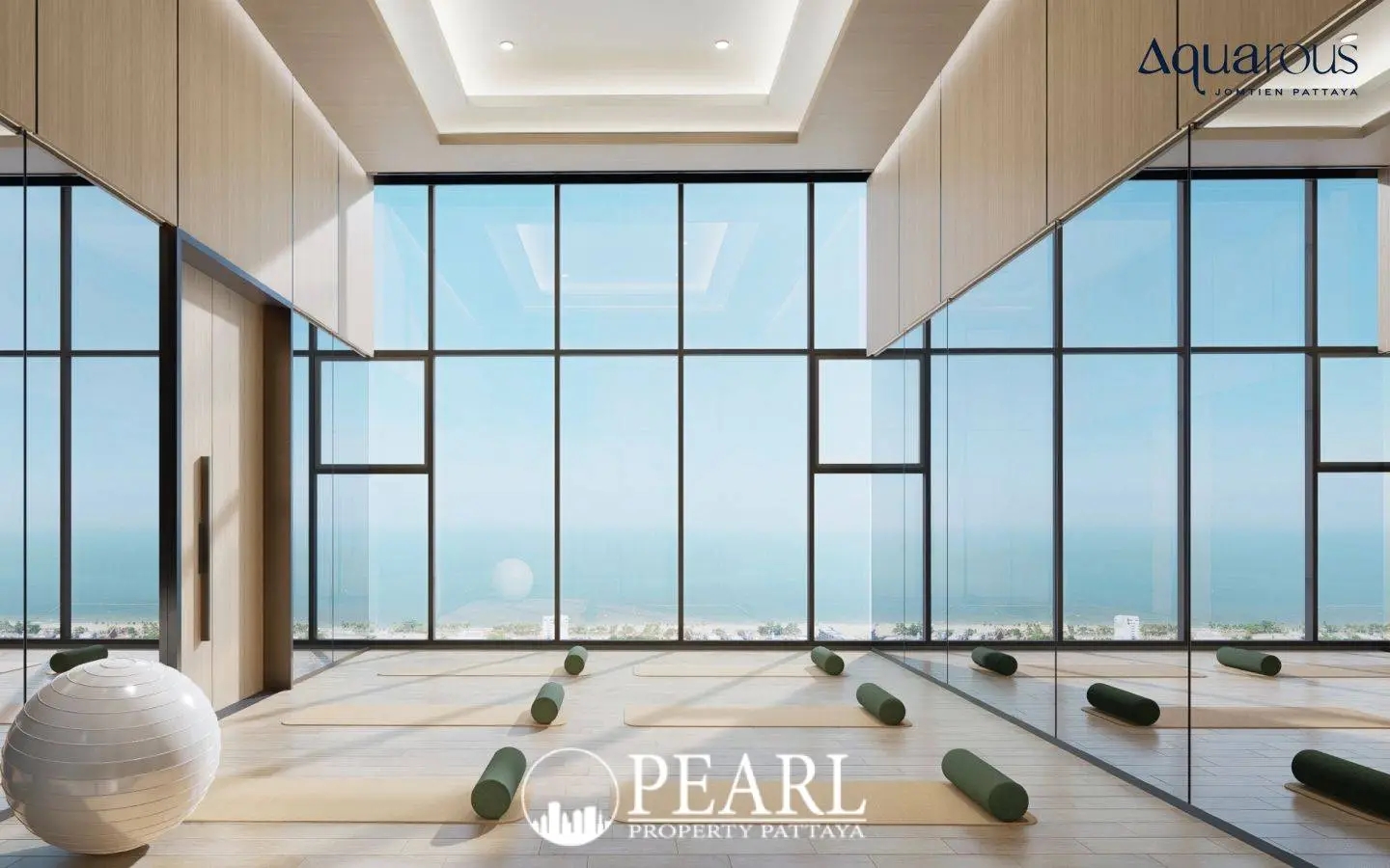 2 Bedroom Executive Suite Condo for Sale at Aquarous Jomtien Pattaya yoga room with large windows overlooking the ocean.