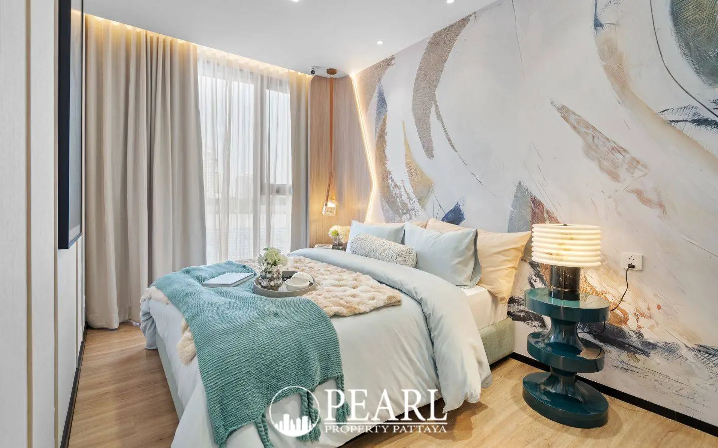 3 Bedroom Condo for Sale at Aquarous Jomtien Pattaya: Stylish bedroom with large window, abstract wall art, and bedside lamp.
