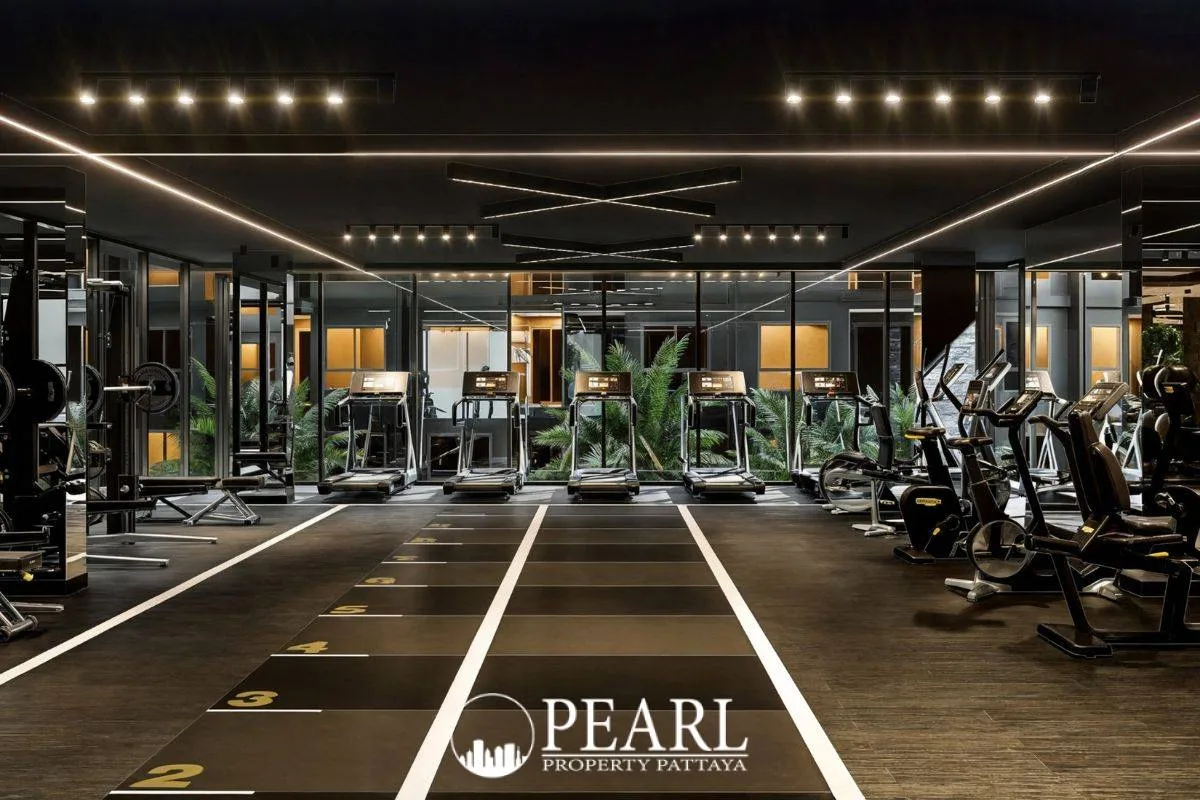 Zenith Pattaya outdoor swimming pool with white lounge chairs, surrounded by modern buildings and green landscaping.