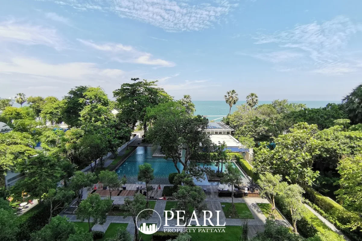 Zire Wongamat aerial view of the large outdoor swimming pool surrounded by green trees and ocean.