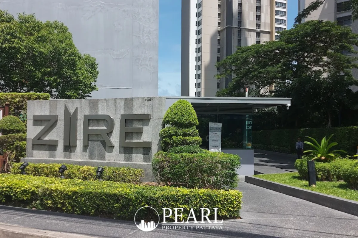 Zire Wongamat entrance sign with lush green hedges and property building in background.