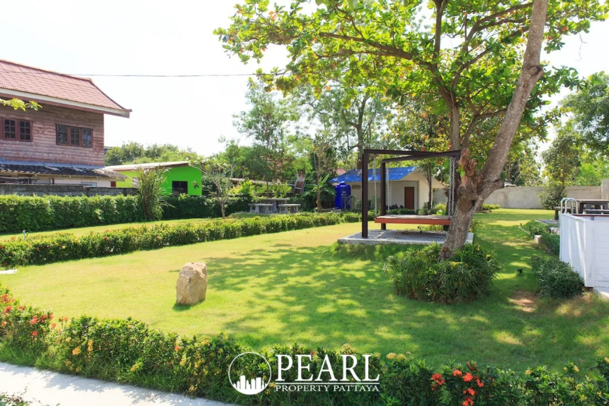 The Maple Pattaya outdoor swimming pool with blue tiles and a modern building in the background.