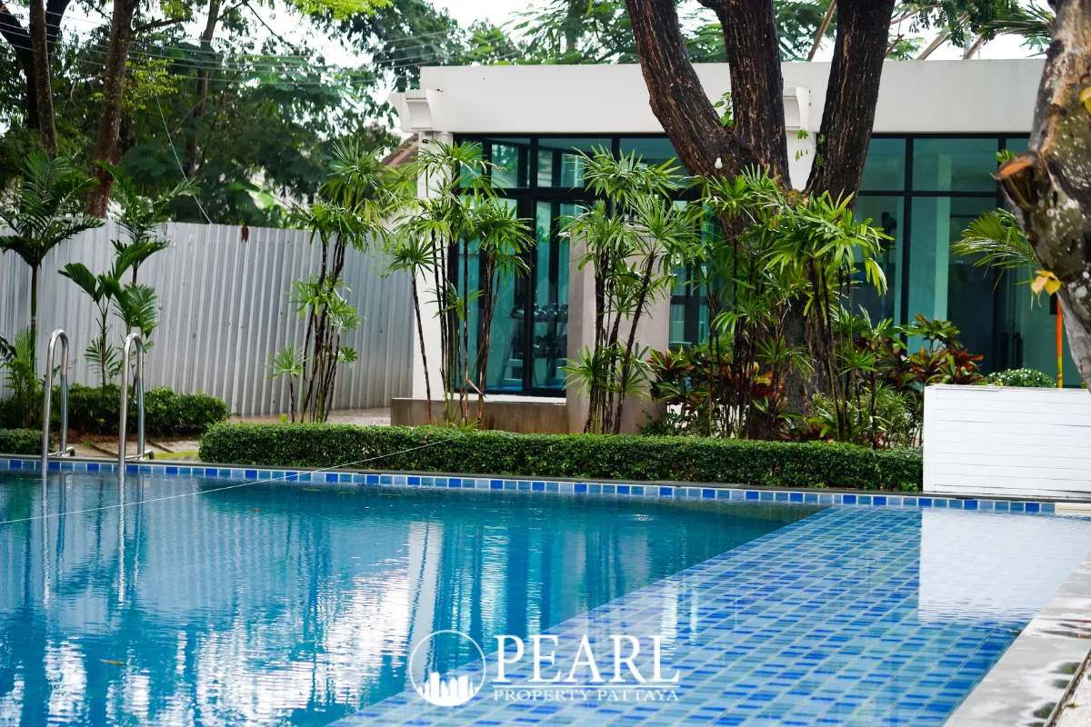 The Maple Pattaya large outdoor swimming pool with blue tiles and a pink flamingo float.