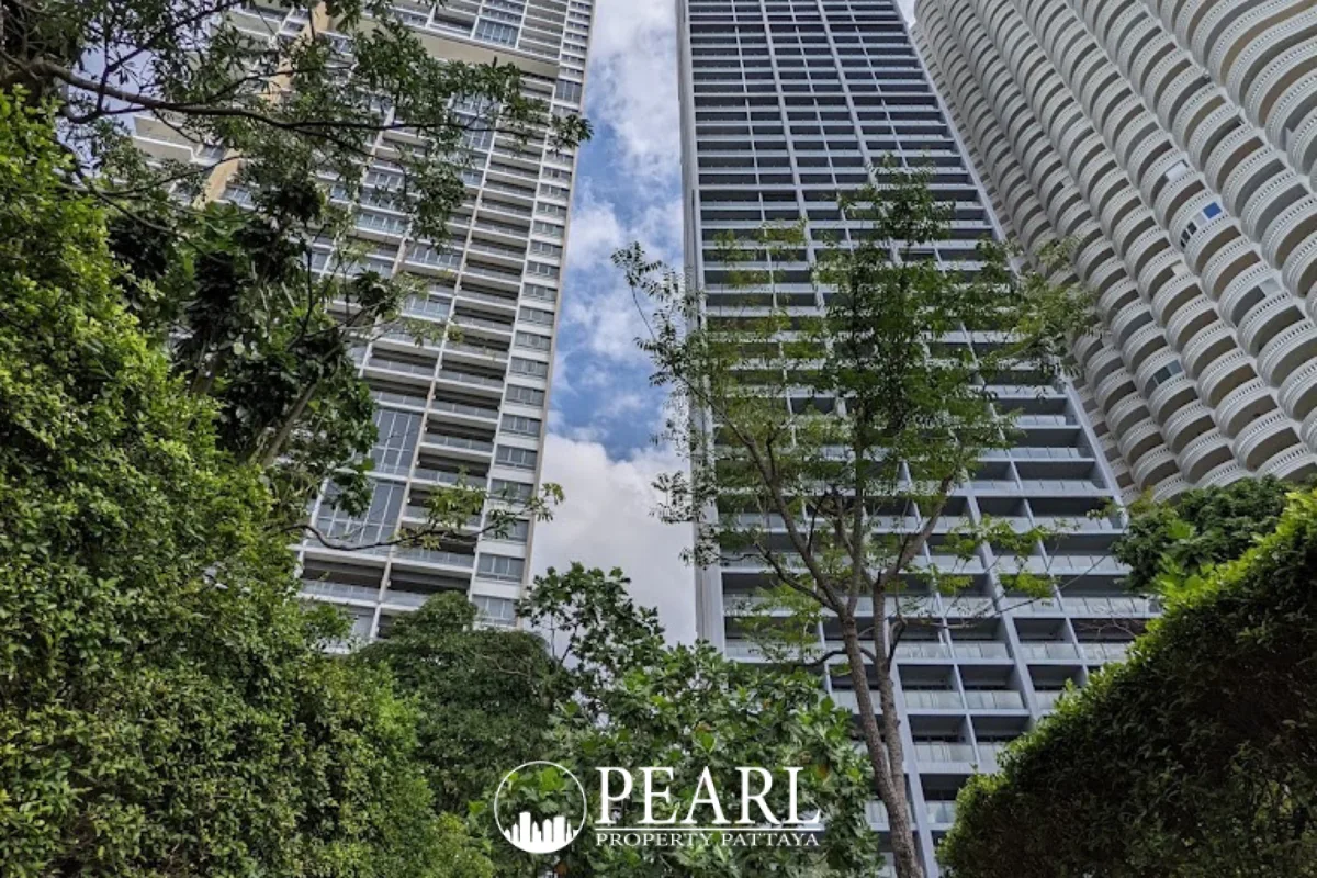 Zire Wongamat exterior view of two modern high-rise condo buildings through green foliage.