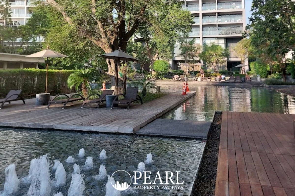 Zire Wongamat outdoor swimming pool area with fountains, wooden decks, and lounge chairs.