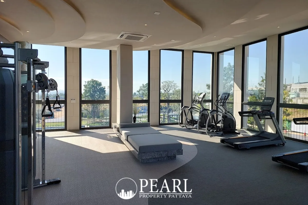 Cascade long, narrow reflective water feature next to a modern building under a clear blue sky.