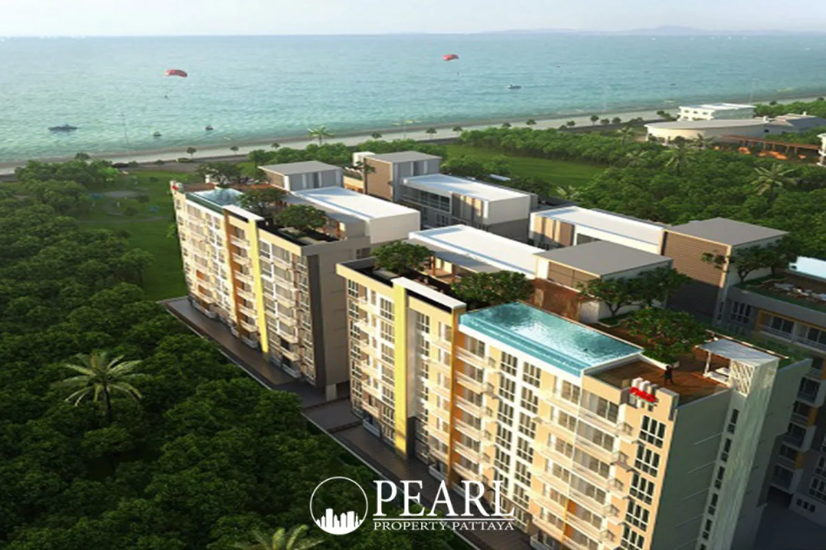Neo Sea View: Aerial view of condo buildings with rooftop pools, lush greenery, and the ocean with parasails in Pattaya.