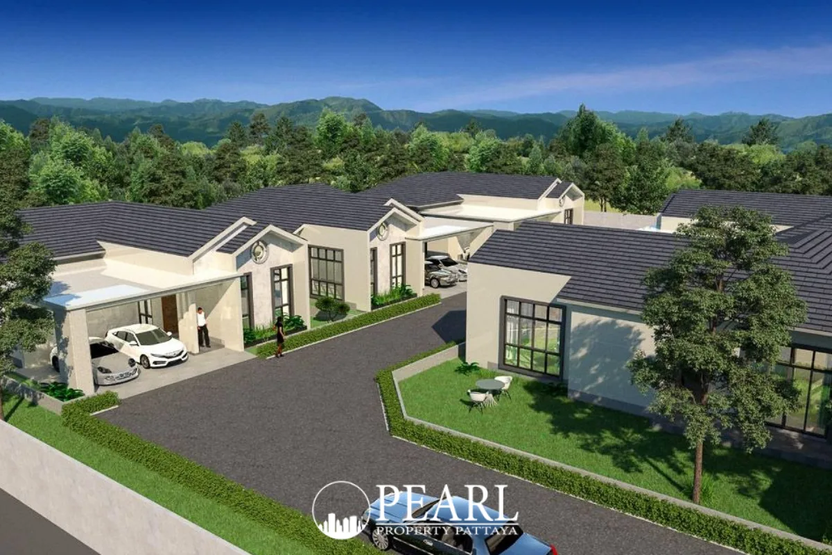 The Hamlet Pattaya, aerial view of multiple modern houses with carports, surrounded by lush green trees and mountains.